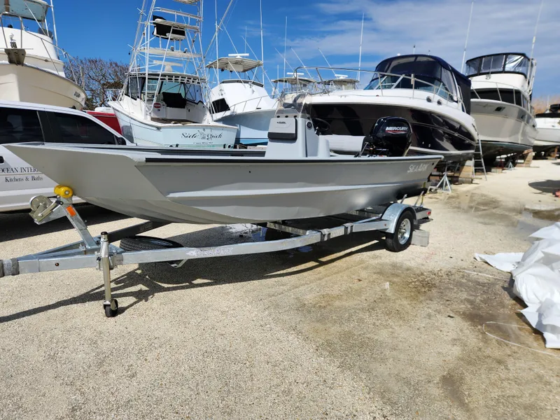 Slide: The Image of 2025 SeaArk 1872 MVT boat on trailer, surrounded by other boats in a marina. - 3