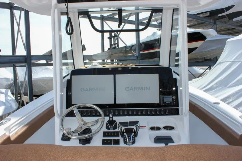 Slide: The Image of 2025 Sea Hunt Gamefish 28 helm with dual Garmin displays and steering wheel. - 30