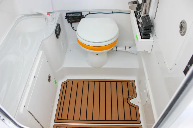 Slide: The Image of 2025 Sea Hunt Gamefish 28 Forward Seating boat interior with toilet and wooden floor mat. - 46