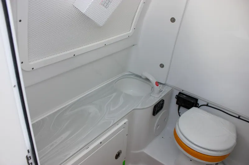 Slide: The Image of 2025 Sea Hunt Gamefish 28 Forward Seating boat interior with compact marine toilet. - 47