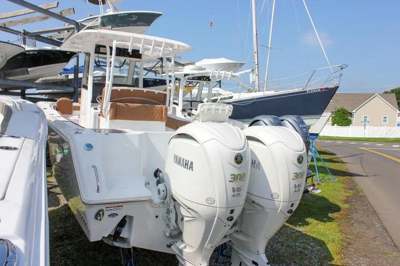 Slide: The Image of 2025 Sea Hunt Gamefish 28 with twin Yamaha 300 engines, docked near other boats. - 5