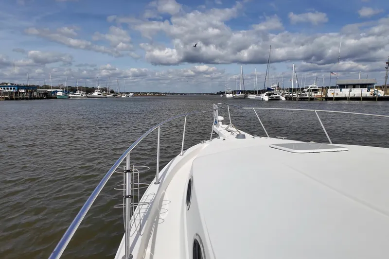 Slide: The Image of 2004 Wellcraft 330 Coastal boat navigating a marina under a partly cloudy sky. - 19