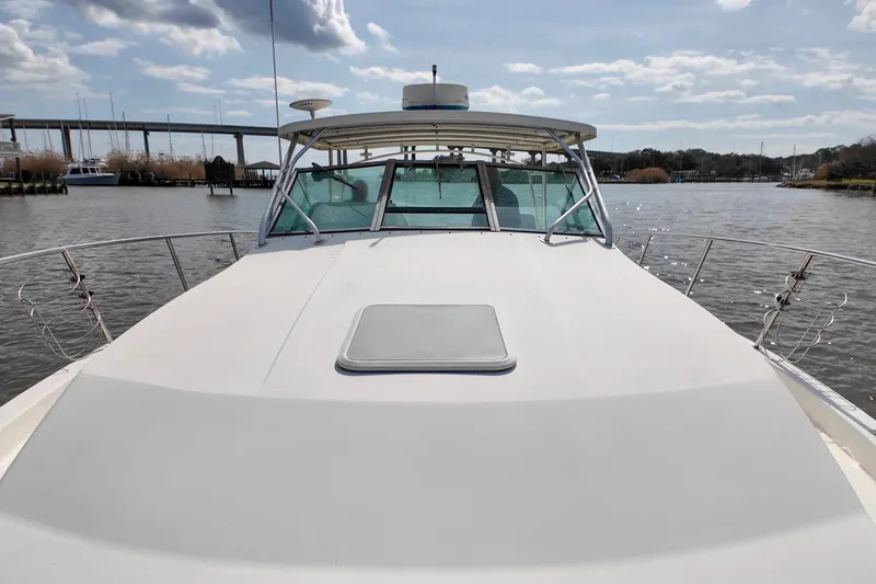 Slide: The Image of 2004 Wellcraft 330 Coastal boat on calm water under a partly cloudy sky. - 20