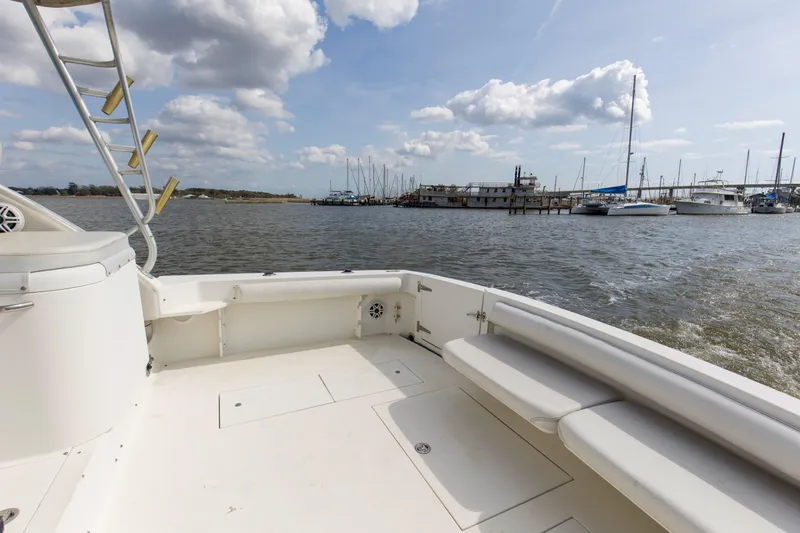 Slide: The Image of 2004 Wellcraft 330 Coastal boat deck with marina view, under a partly cloudy sky. - 22