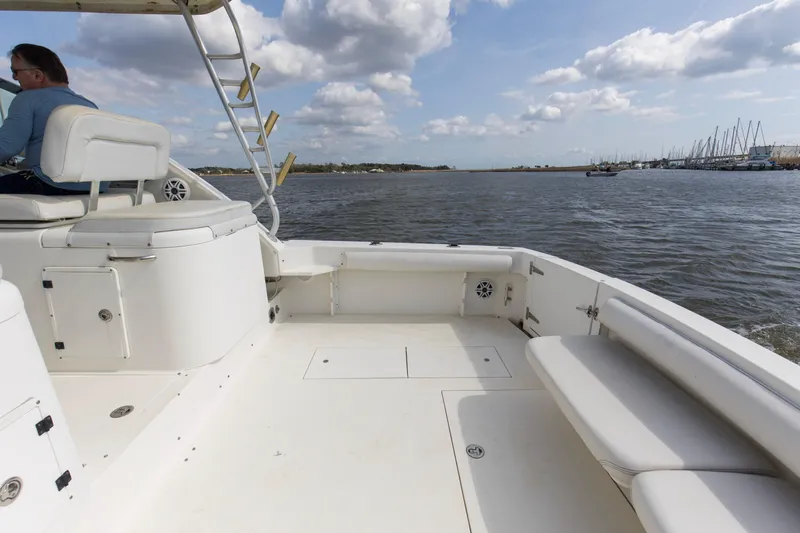 Slide: The Image of 2004 Wellcraft 330 Coastal boat on water, featuring spacious deck and seating. - 25