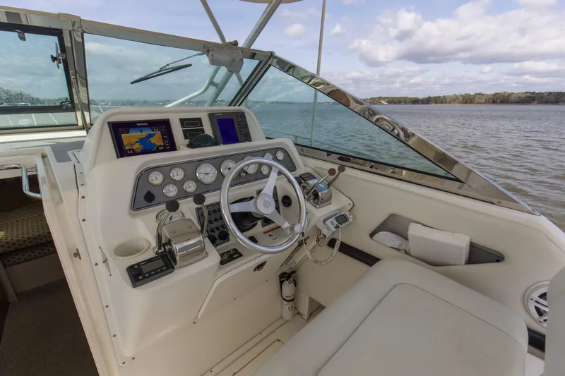 Slide: The Image of 2004 Wellcraft 330 Coastal boat helm with navigation instruments on a calm lake. - 26