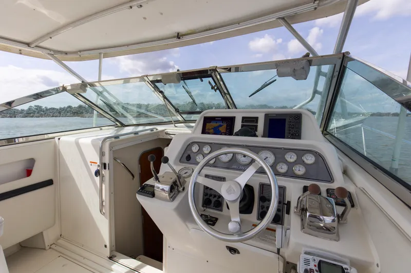 Slide: The Image of 2004 Wellcraft 330 Coastal boat cockpit with steering wheel and navigation instruments. - 27