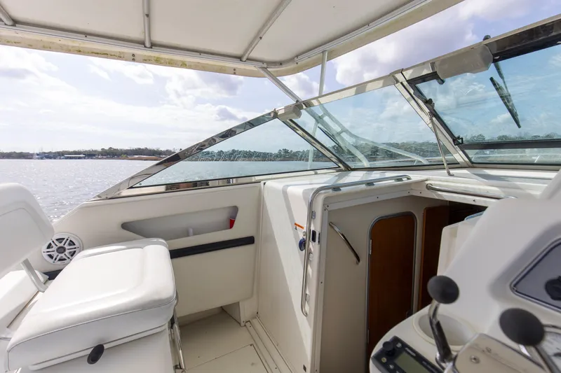 Slide: The Image of 2004 Wellcraft 330 Coastal boat interior with helm, seating, and water view. - 29