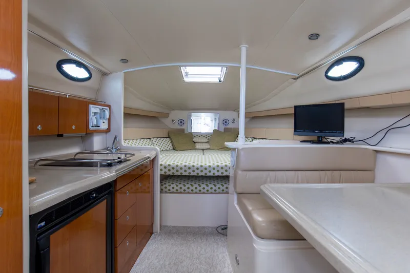 Slide: The Image of 2004 Wellcraft 330 Coastal cabin interior with kitchenette, seating, and bed. - 31