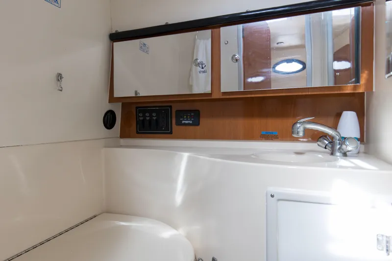 Slide: The Image of 2004 Wellcraft 330 Coastal boat bathroom with sink, mirror, and control panel. - 35