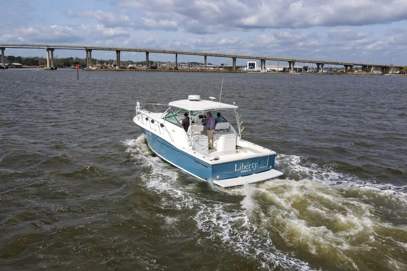Slide: The Image of 2004 Wellcraft 330 Coastal boat cruising on a river with a bridge in the background. - 4