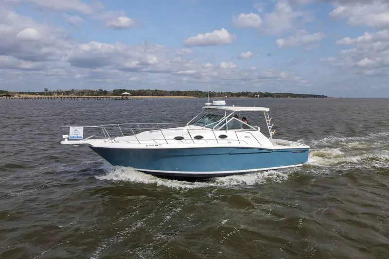 Slide: The Image of 2004 Wellcraft 330 Coastal boat cruising on open water under a partly cloudy sky. - 6