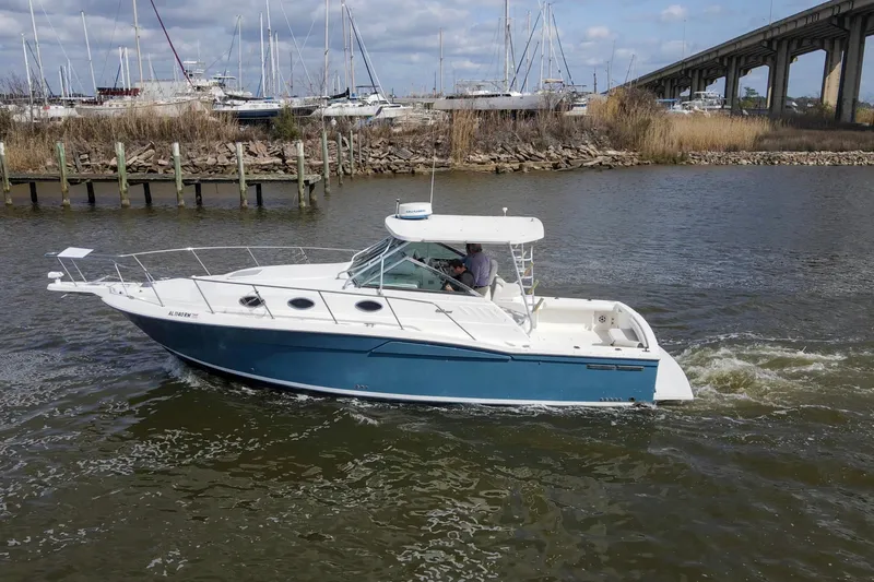 Slide: The Image of 2004 Wellcraft 330 Coastal boat cruising on a river near a marina and bridge. - 9