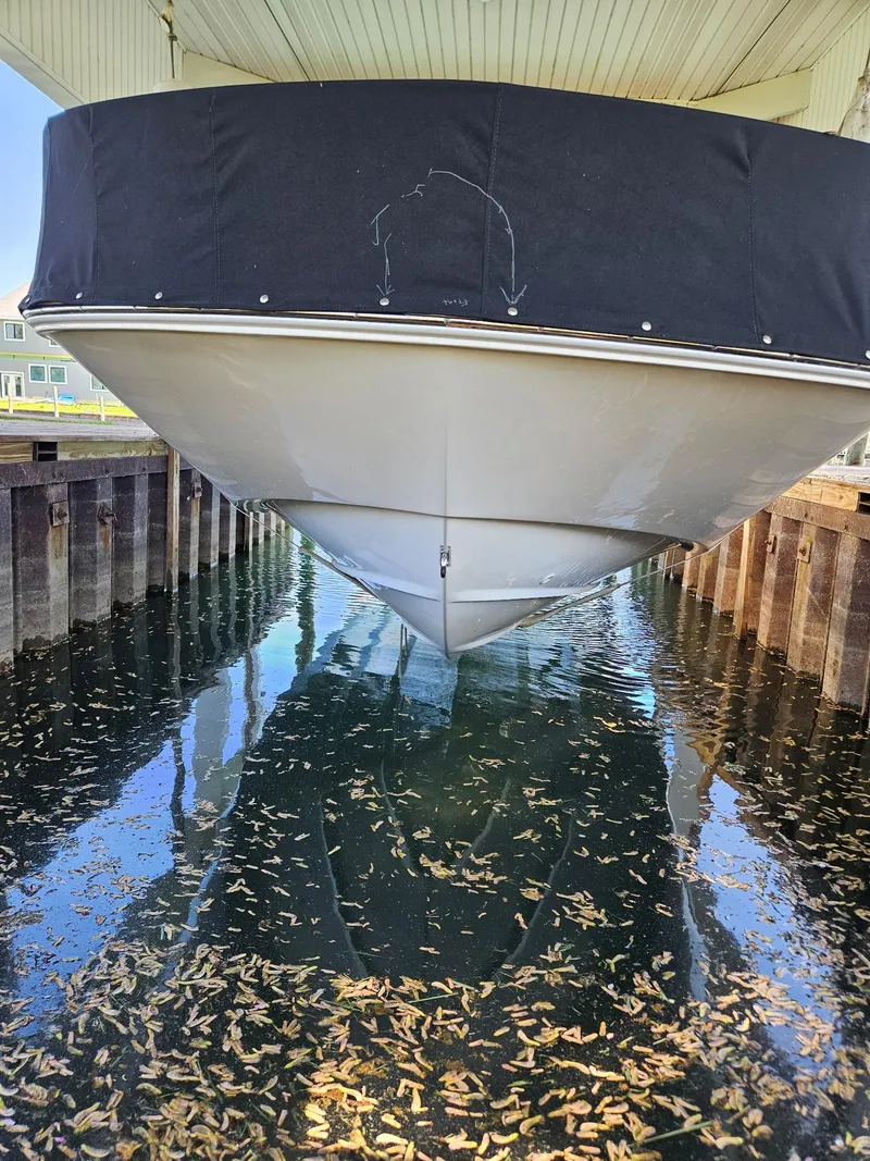 Slide: The Image of 2022 Boston Whaler 210 Montauk boat interior with parked vehicles in the background. - 15