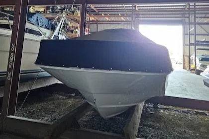 Slide: The Image of 2022 Boston Whaler 210 Montauk boat on trailer, covered, parked on cracked pavement. - 4