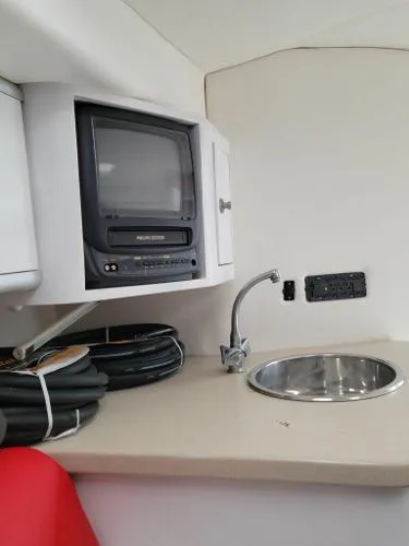 Slide: The Image of Interior of a 2000 Baja 442 boat with TV, sink, and storage. - 10