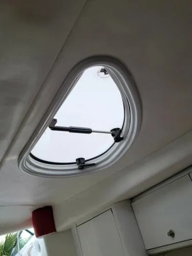 Slide: The Image of Boat interior hatch of a 2000 Baja 442, featuring a sleek, oval design. - 11