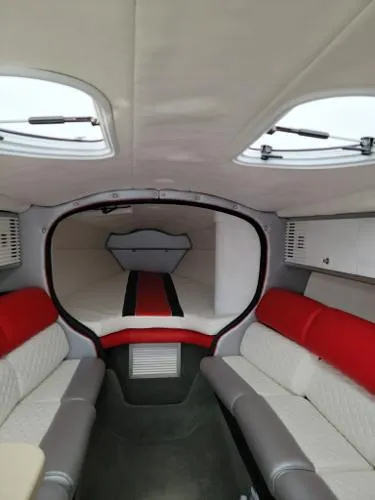 Slide: The Image of Interior of a 2000 Baja 442 boat with red and white seating. - 12