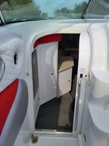 Slide: The Image of 2000 Baja 442 boat interior with red and white seating, open cabin door. - 13