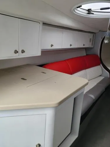 Slide: The Image of Interior of a 2000 Baja 442 boat with white cabinets and red seating. - 4