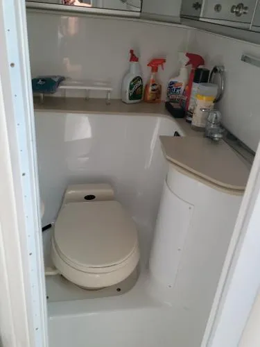 Slide: The Image of Compact bathroom in a 2000 Baja 442 boat with cleaning supplies. - 6