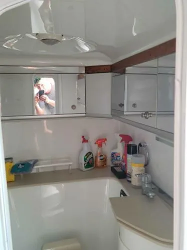 Slide: The Image of Interior of a 2000 Baja 442 boat bathroom with cleaning supplies and mirrored cabinets. - 7