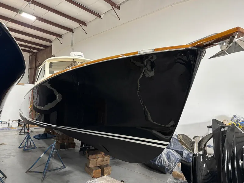 Slide: The Image of 2002 Hinckley Picnic Boat 36 in storage, showcasing sleek black hull and classic design. - 1