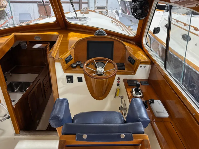 Slide: The Image of Helm of 2002 Hinckley Picnic Boat 36 with wooden accents and modern navigation equipment. - 10