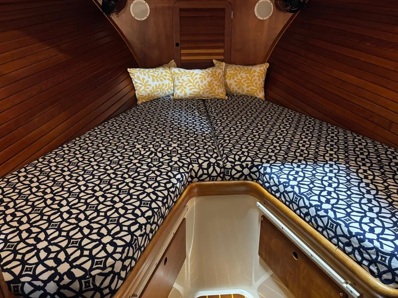 Slide: The Image of Cozy cabin interior of 2002 Hinckley Picnic Boat 36 with patterned bedding and wooden walls. - 12