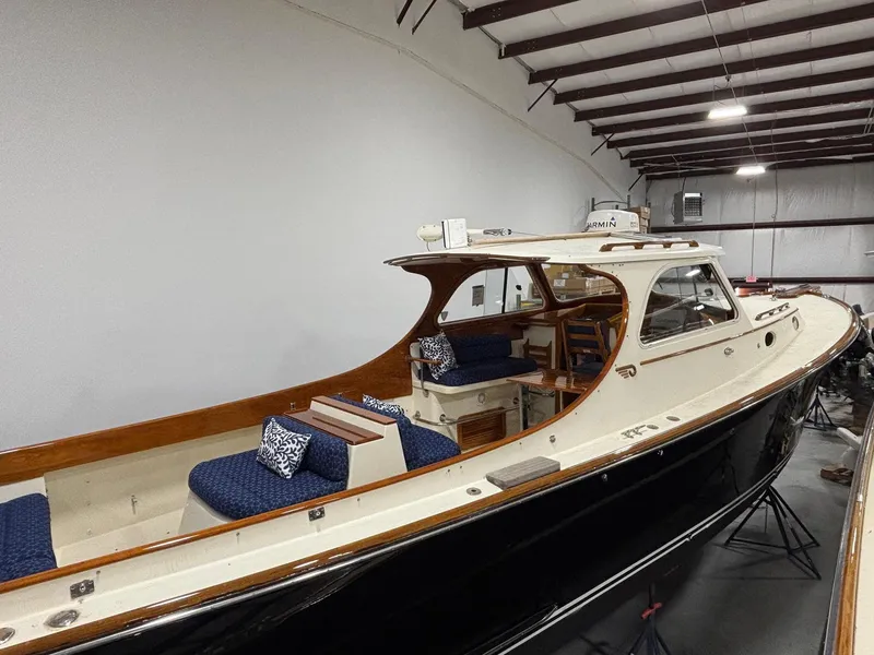 Slide: The Image of 2002 Hinckley Picnic Boat 36 in indoor storage, showcasing elegant design and seating. - 3