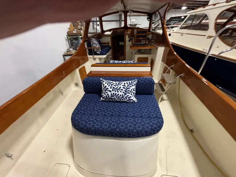 Slide: The Image of 2002 Hinckley Picnic Boat 36 interior with blue cushioned seating and wooden accents. - 6