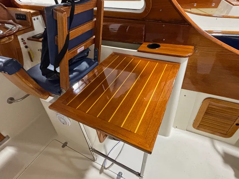 Slide: The Image of 2002 Hinckley Picnic Boat 36 interior with polished wooden table and seating. - 8