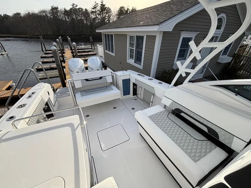 Slide: The Image of 2025 Blackfin 272 DC boat interior with seating, docked near a house. - 20