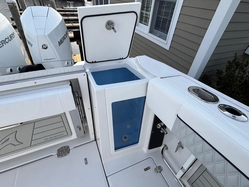 Slide: The Image of 2025 Blackfin 272 DC boat interior with storage compartments and Mercury engines. - 25