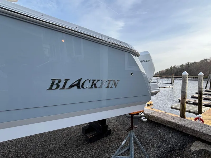 Slide: The Image of 2025 Blackfin 272 DC boat docked by the water on a clear day. - 5