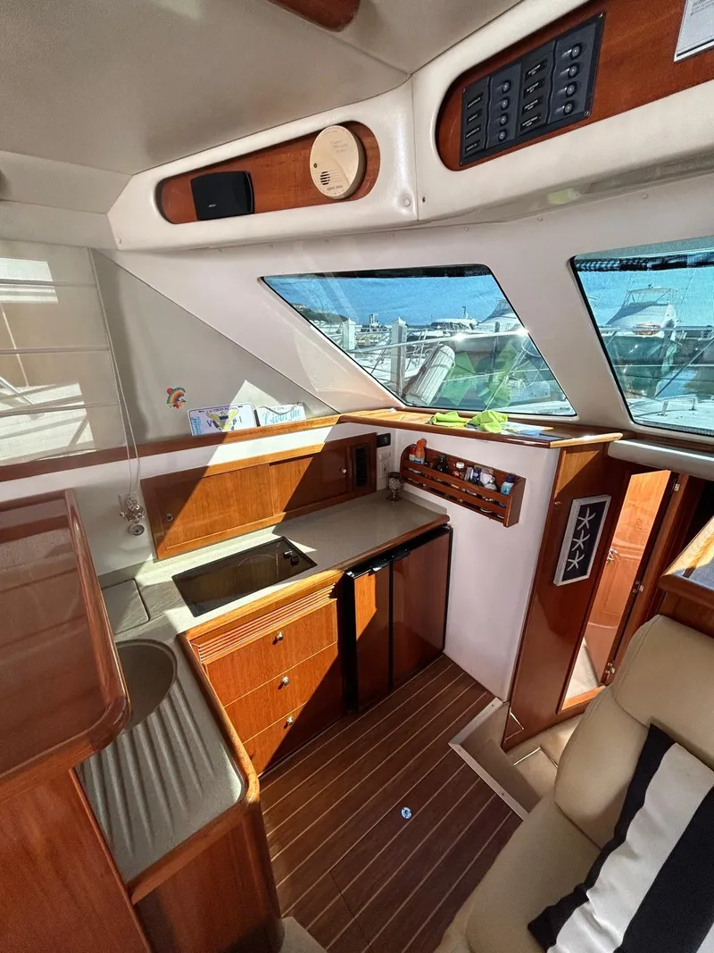 Slide: The Image of 2004 Riviera 40 yacht interior with wooden cabinetry, kitchenette, and large windows. - 4