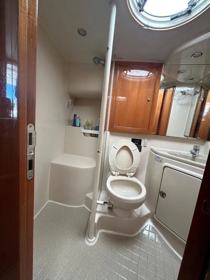 Slide: The Image of 2004 Riviera 40 yacht bathroom with toilet, sink, and wooden cabinetry. - 6