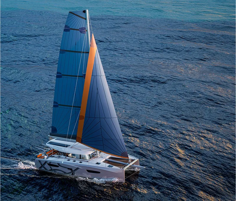 The Image of 2025 Excess 13 catamaran sailing on open sea with vibrant blue sails. - 0