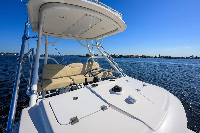 Slide: The Image of 2017 Pursuit S408 boat helm with seating, cruising on open water under clear blue sky. - 34