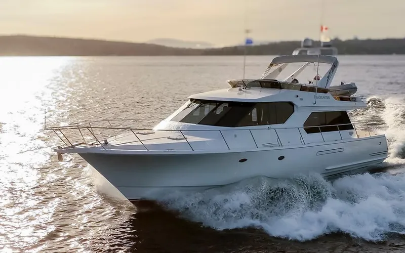 Slide: The Image of 1999 West Bay 58 Pilothouse Motor Yacht cruising on open water at sunset. - 0
