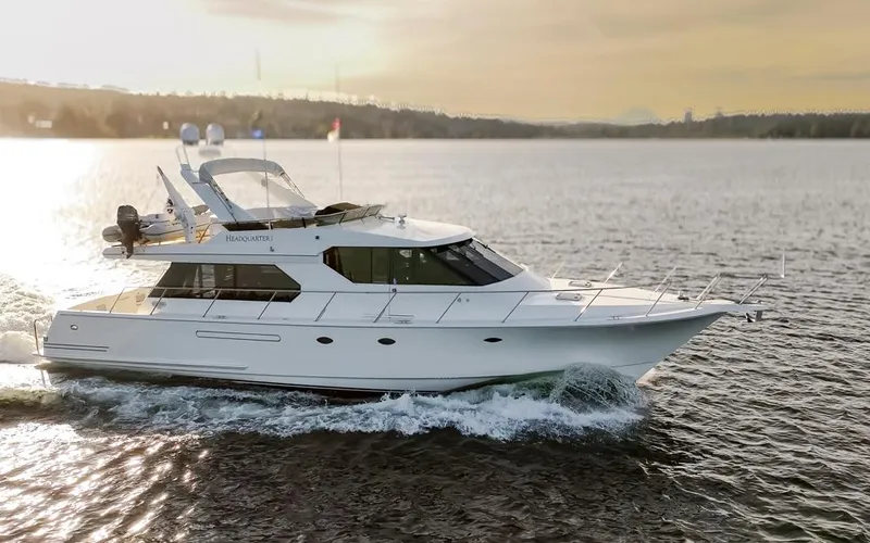 Slide: The Image of 1999 West Bay 58 Pilothouse Motor Yacht cruising on calm waters at sunset. - 2