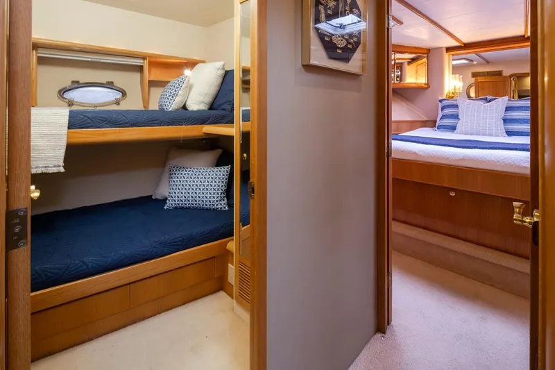 Slide: The Image of Cabin interior of 1999 West Bay 58 Pilothouse Motor Yacht with bunk beds and master bedroom. - 23