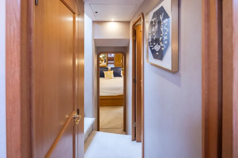 Slide: The Image of Hallway view inside 1999 West Bay 58 Pilothouse Motor Yacht, featuring elegant wood finishes. - 26