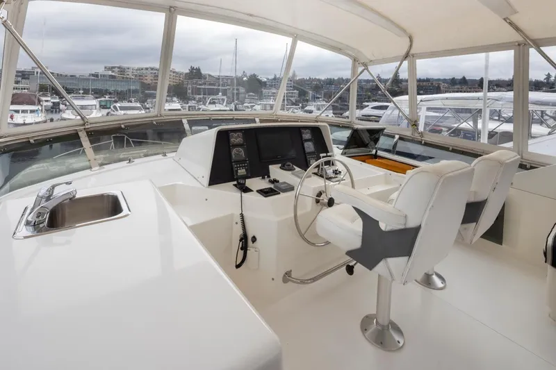 Slide: The Image of 1999 West Bay 58 Pilothouse Motor Yacht helm with dual seats and navigation equipment. - 29