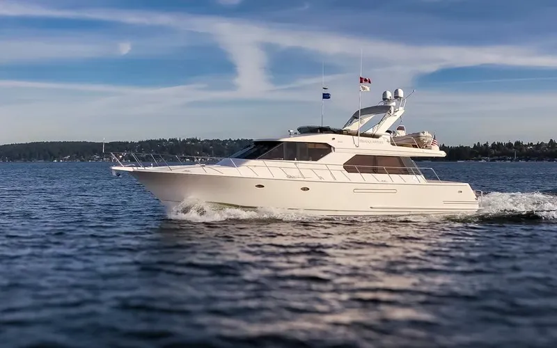 Slide: The Image of 1999 West Bay 58 Pilothouse Motor Yacht cruising on open water under a clear sky. - 3