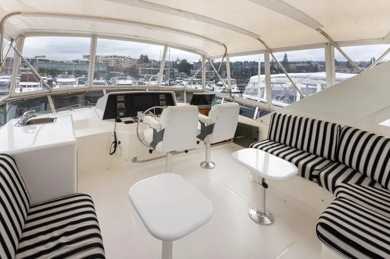 Slide: The Image of 1999 West Bay 58 Pilothouse Motor Yacht interior with striped seating and helm station. - 31
