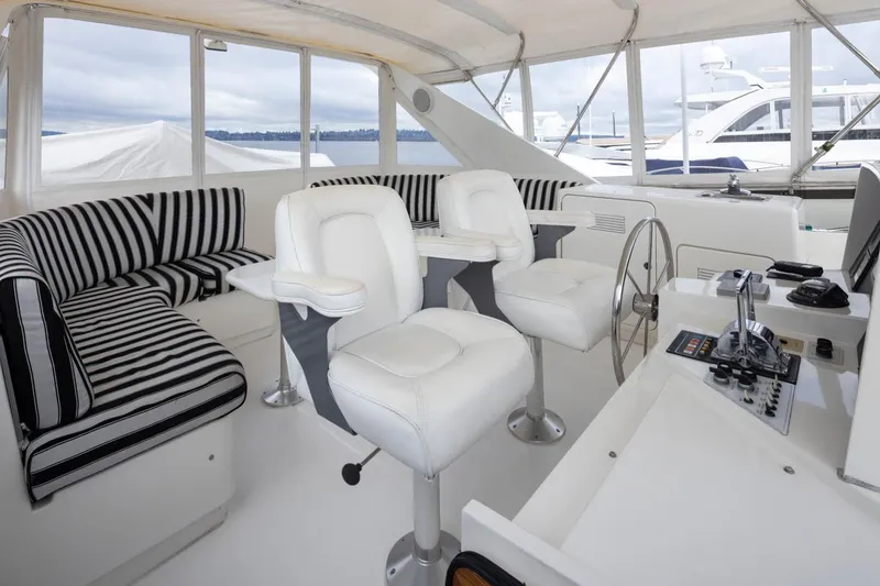 Slide: The Image of 1999 West Bay 58 Pilothouse Motor Yacht interior with striped seating and helm station. - 32