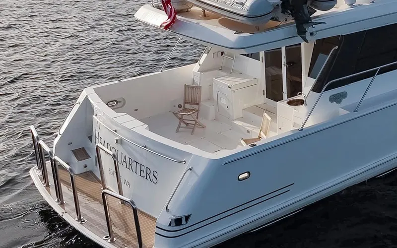 Slide: The Image of 1999 West Bay 58 Pilothouse Motor Yacht on water, featuring spacious deck and elegant design. - 4