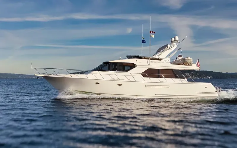 Slide: The Image of 1999 West Bay 58 Pilothouse Motor Yacht cruising on open water under a clear sky. - 46