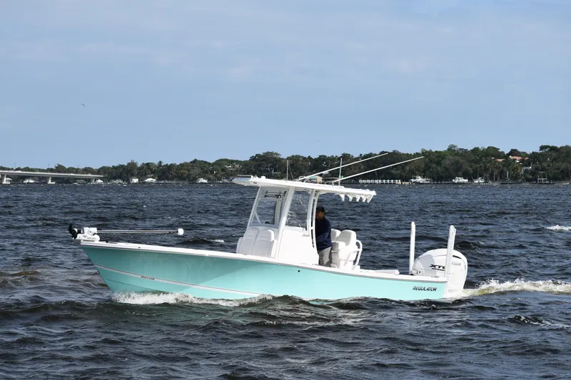 Slide: The Image of 2024 Regulator 26XO boat cruising on open water under a clear sky. - 1